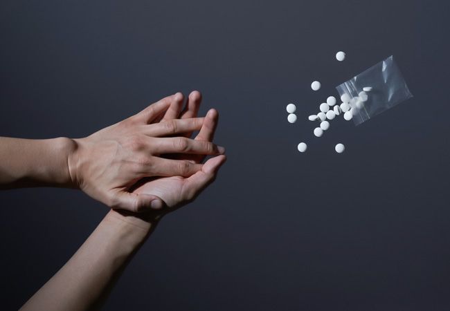 Две руки сцеплены вместе в жесте сопротивления наркотикам на тёмном фоне